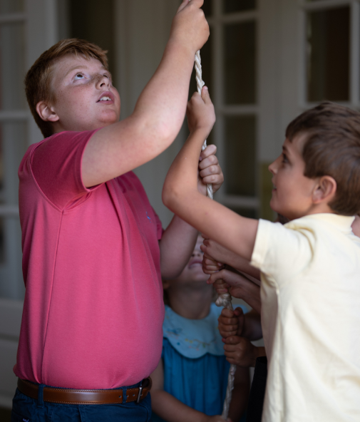 Young people pull a bell rope together.